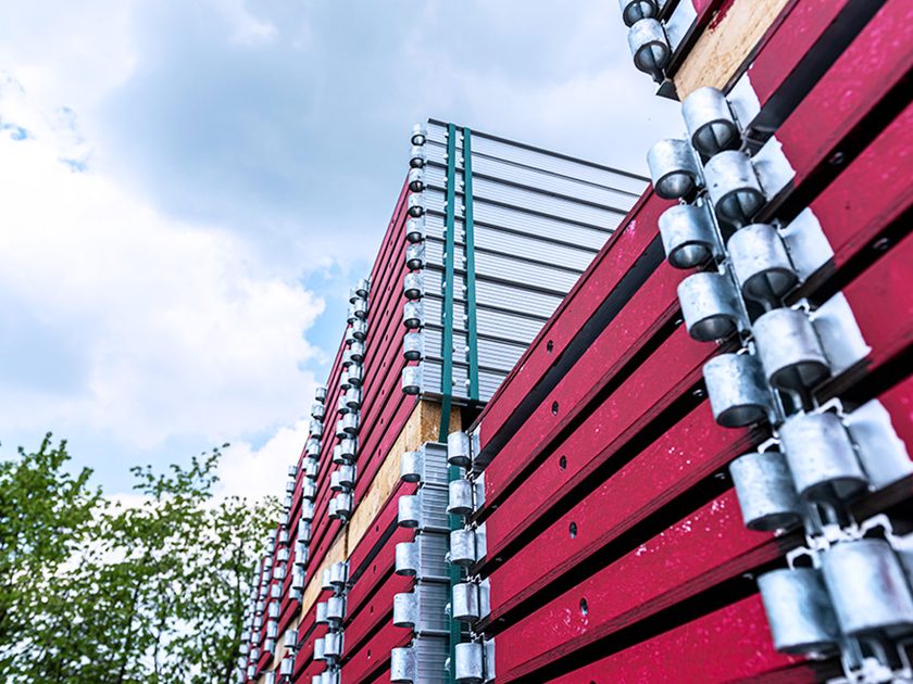Gestapelte Gerüstbauteile mit roten Belägen